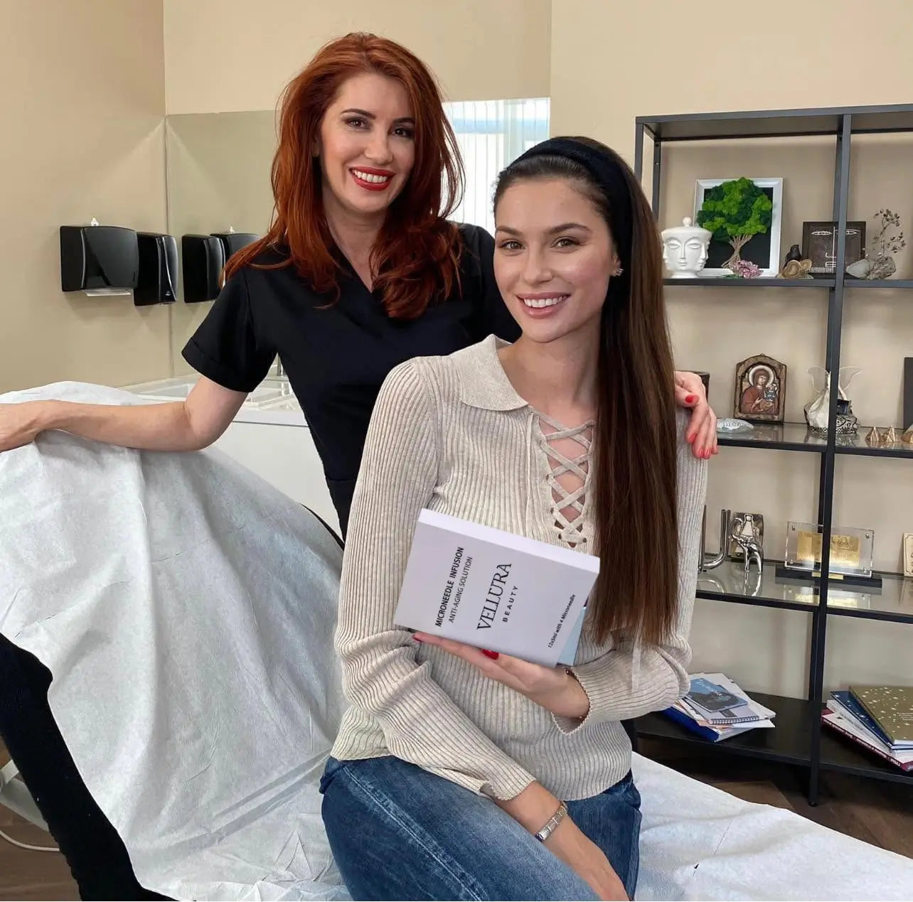 Two women in a bedroom setting, one holding a book titled 'Yellow'.